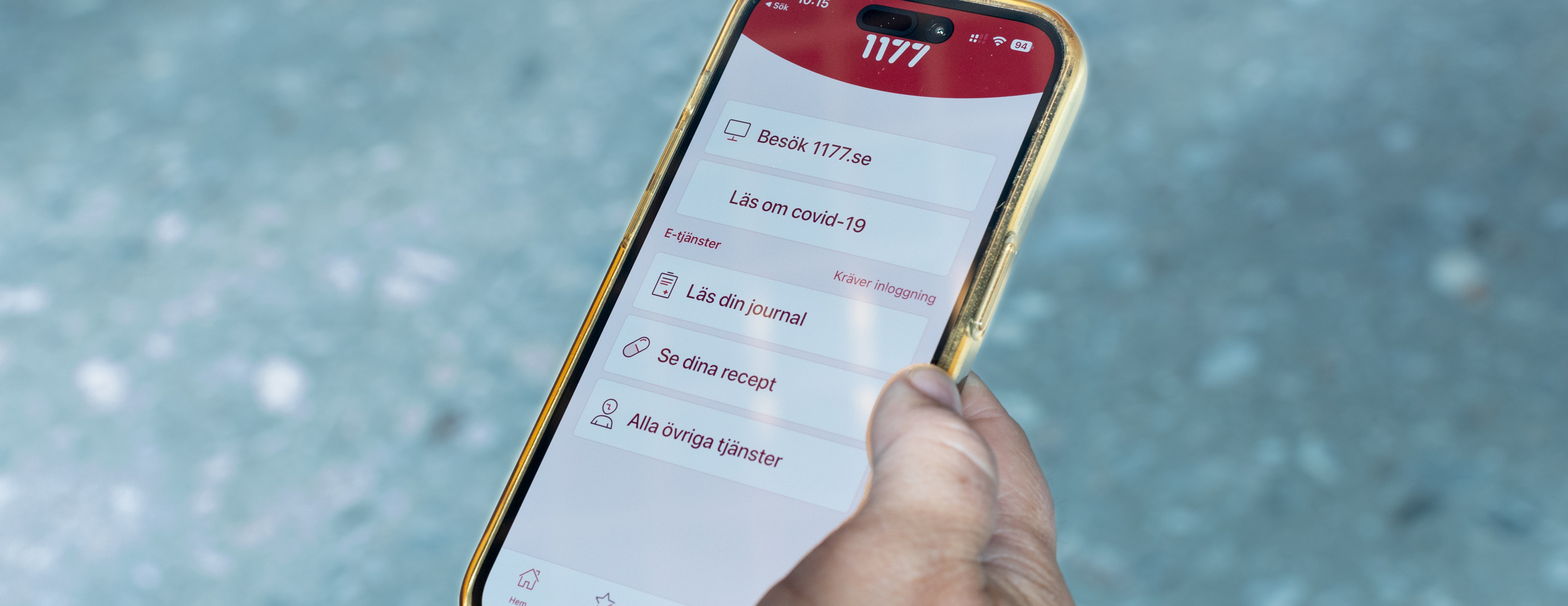 Hand håller i en mobil som visar 1177-appen.