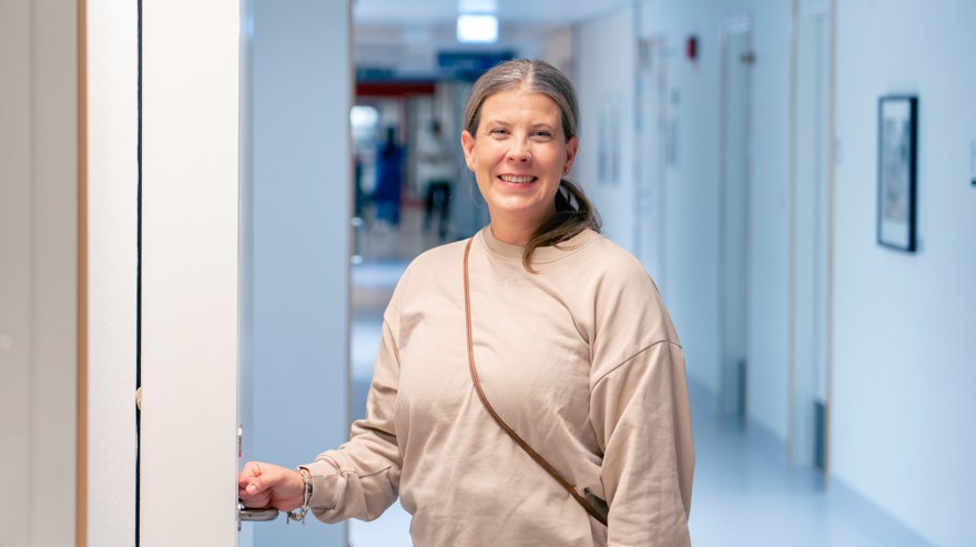 Kvinna i en korridor framför en dörr