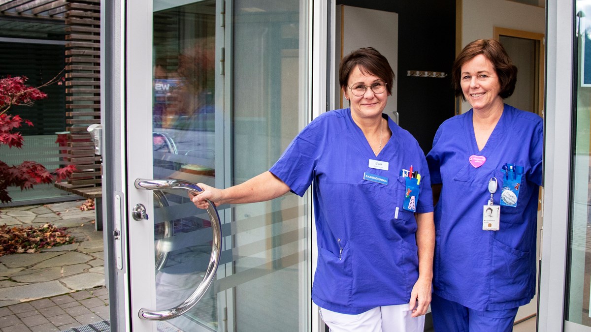 Två sjuksköterskor som står i en öppen dörr.