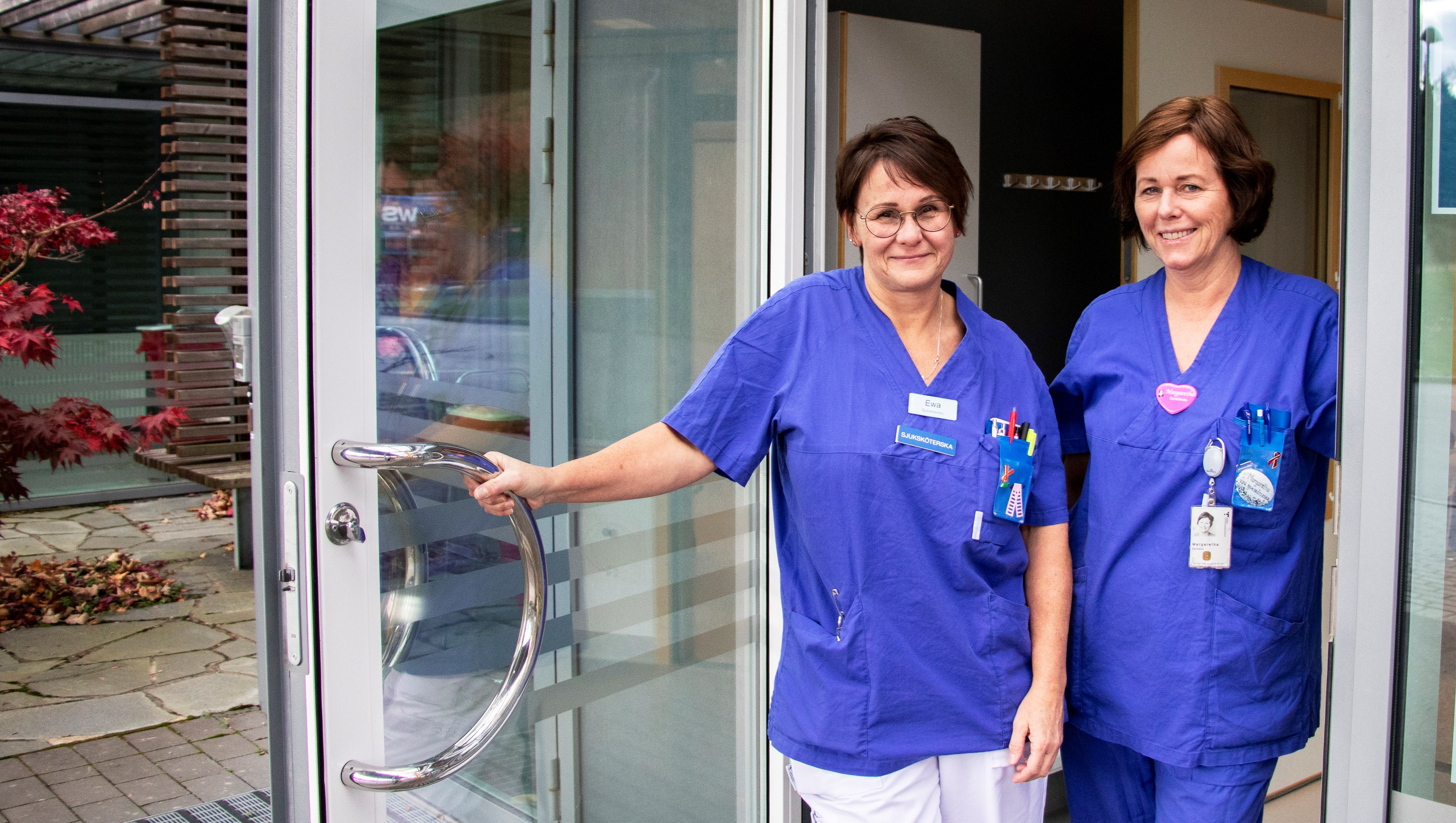 Två sjuksköterskor som står i en öppen dörr.