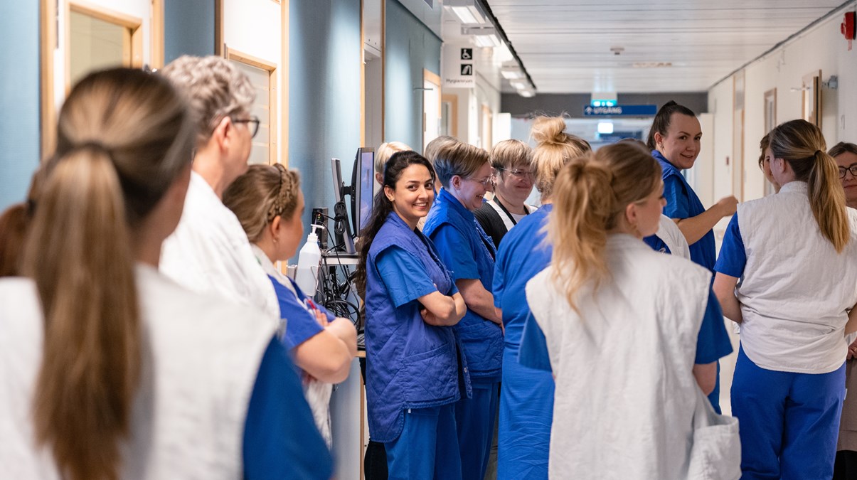 Grupp med kvinnor i sjukhuskläder i en korridor